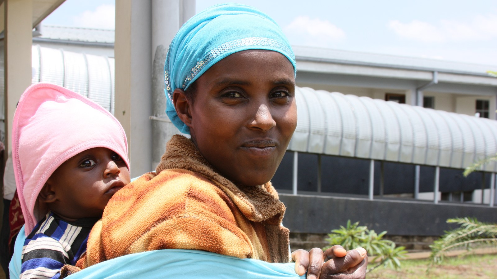 Health worker supporting a family in a drought-affected setting